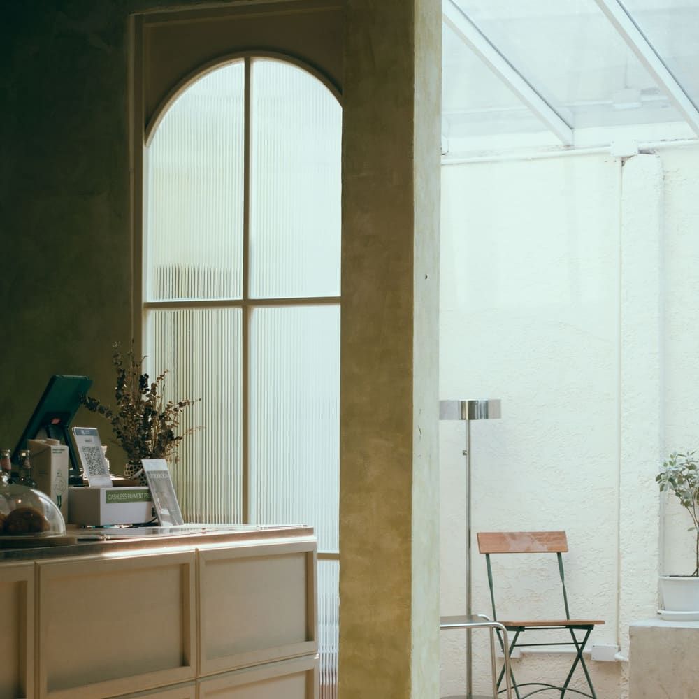 A softly lit reception counter beside a tall arched window.